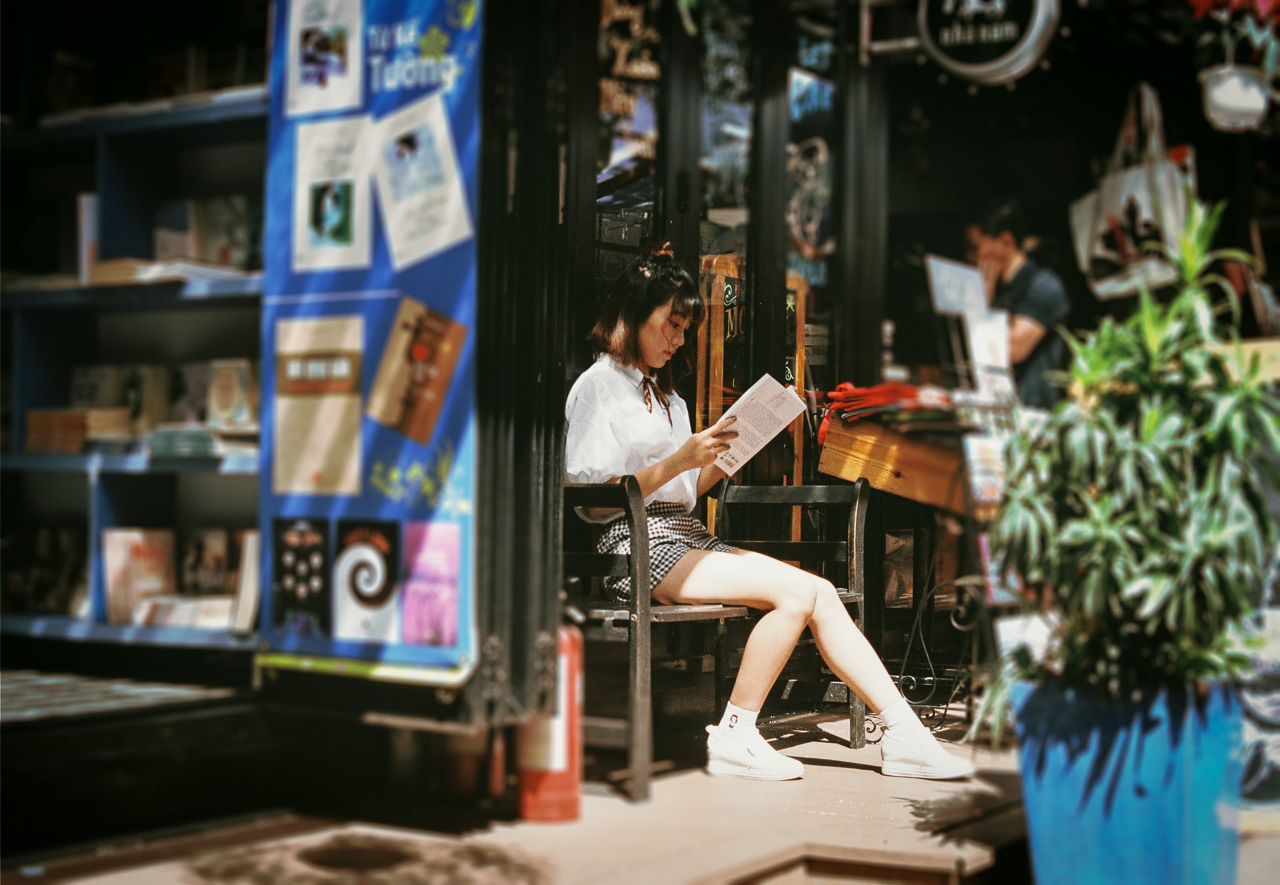 candid photo of a woman reading at a roadside stall
