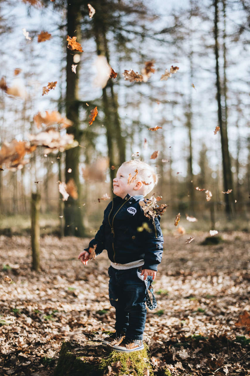 happy kid playing with leaves