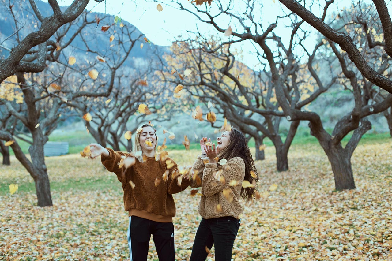 two friends playing with leaves
